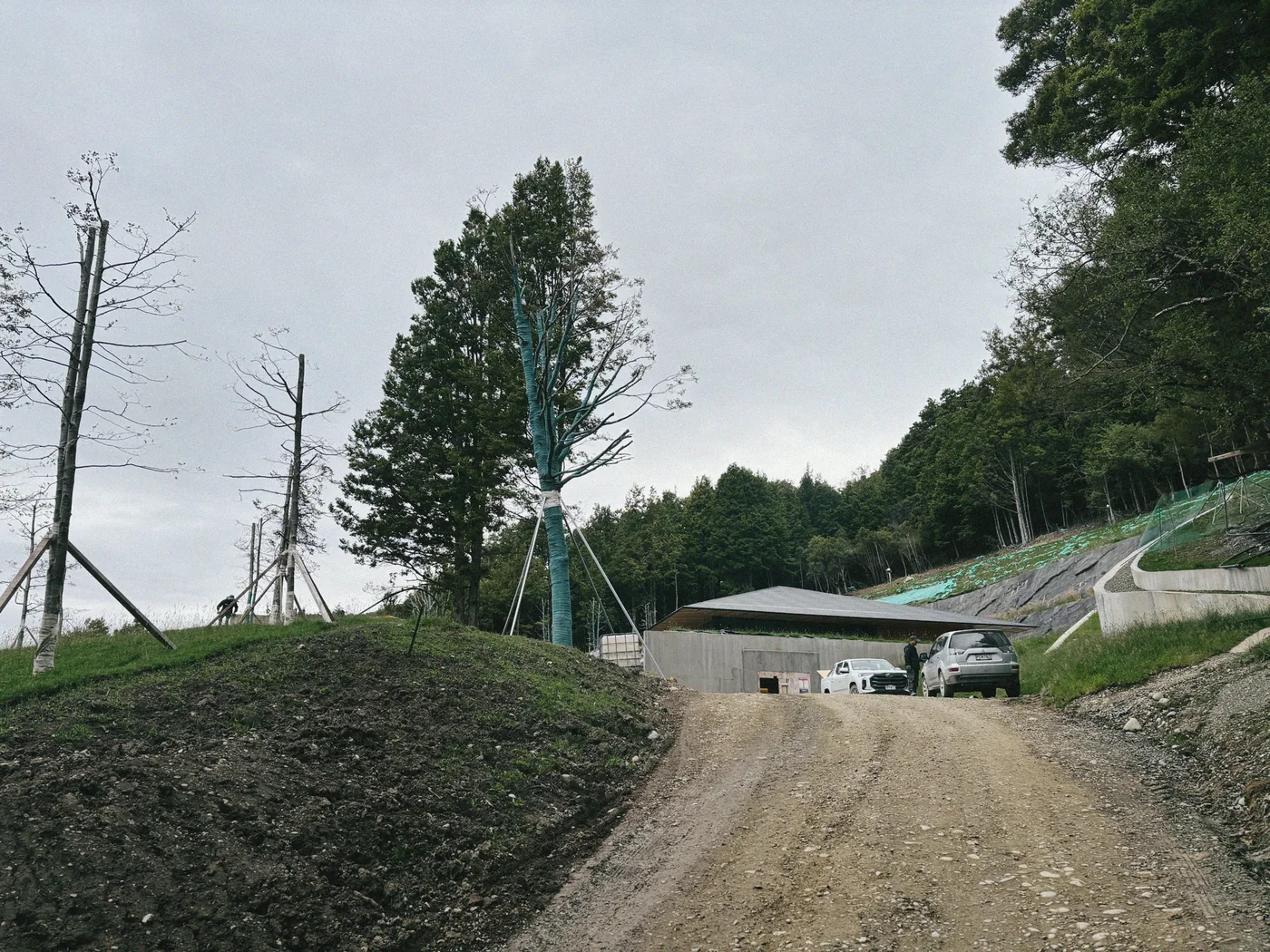 The building emerging from its hillside during construction