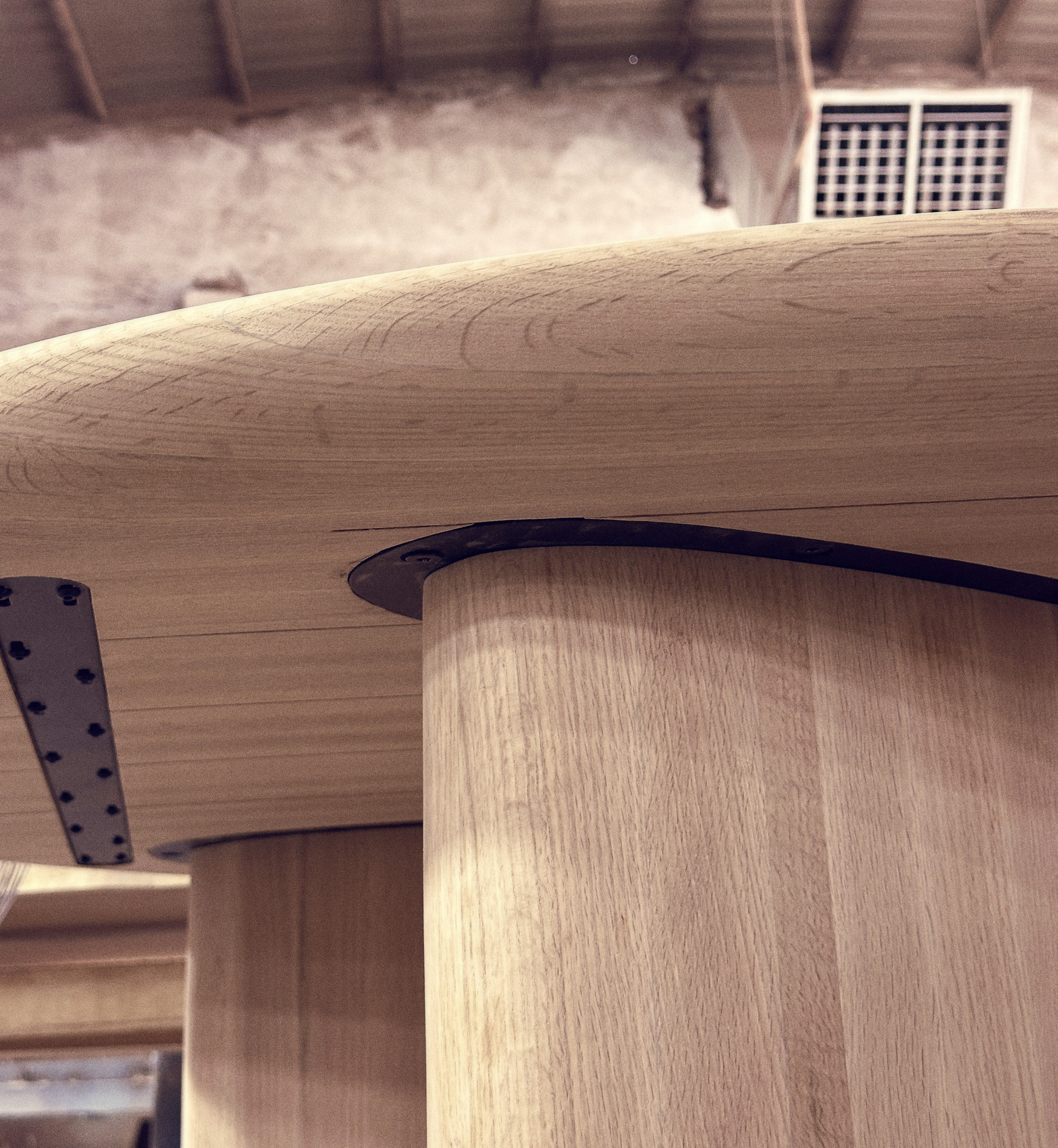 The underside of a table top, showing the leg mounting plate and steel stiffener