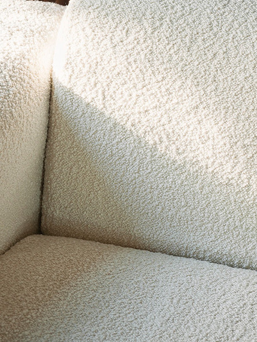 Sora Sofa — Dedar Karakorum bouclé corner detail, raking light against fluted oak and green marble